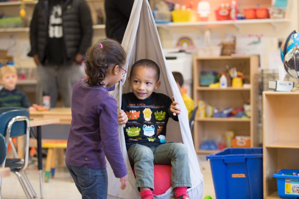 early childhood students play in the classroom swing